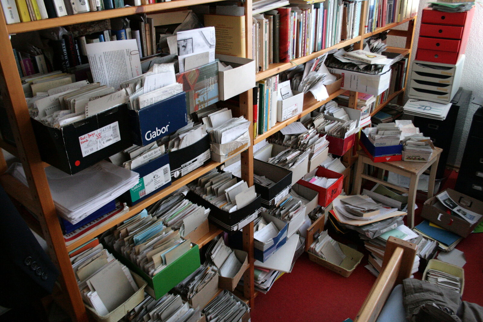Shelves full of shoe boxes with slips of paper, with books in between